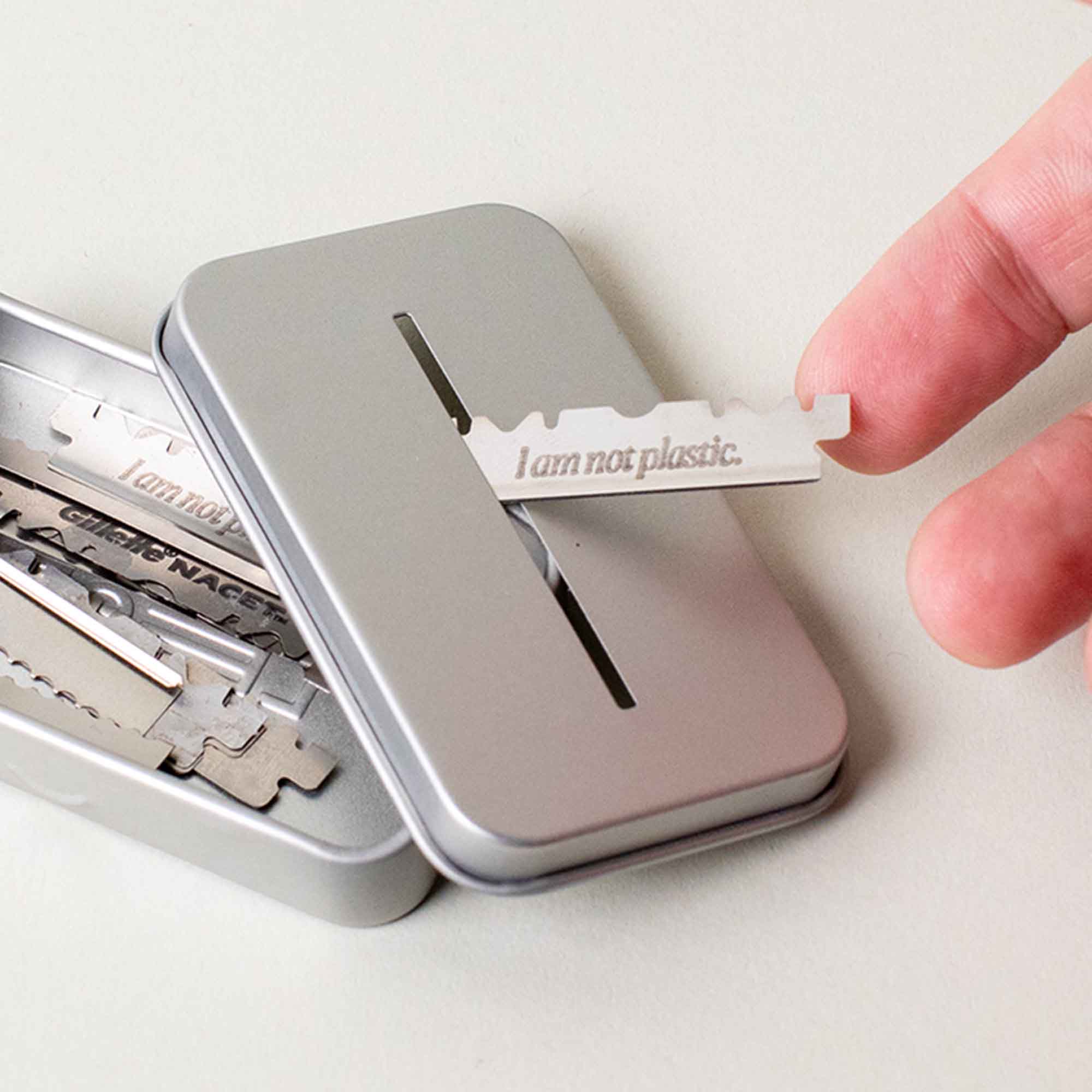 User puts a blade into the slit of the recycling tin while the lid is off