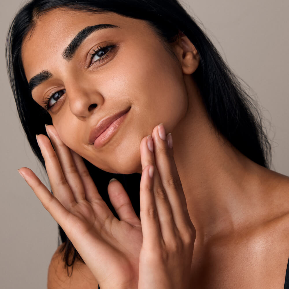 Woman feels her cheek and chin