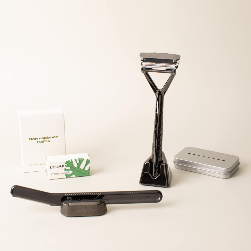 The mercury full face and body kit displayed with the leaf razor, dermaplaner, a stand and blades, for each, and the recycling tin