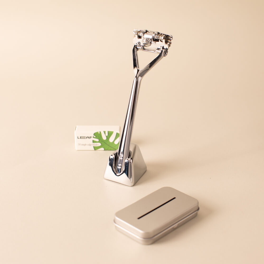 The chrome Leaf razor kit with the razor, stand, package of blades, and recyclable tin 