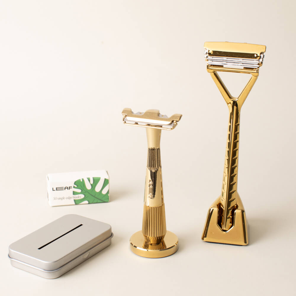 A gold razor set kit with a Leaf and single edge razors, blades, and recycling tin