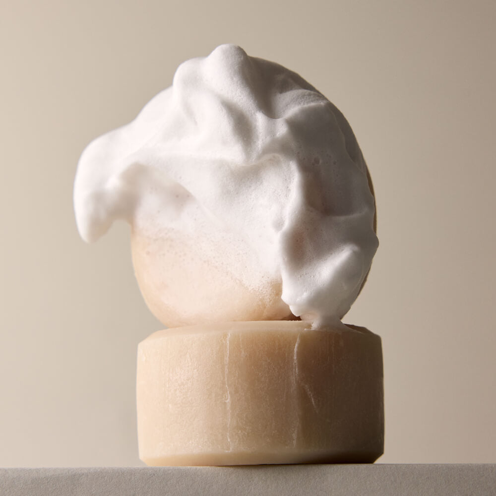 A soapy shave soap bar on top of another